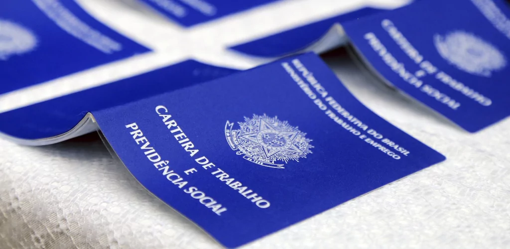 Carteiras de trabalho abertas e viradas para baixo. Quatro carteiras de trabalho abertas e viradas para baixo, com a capa para cima.